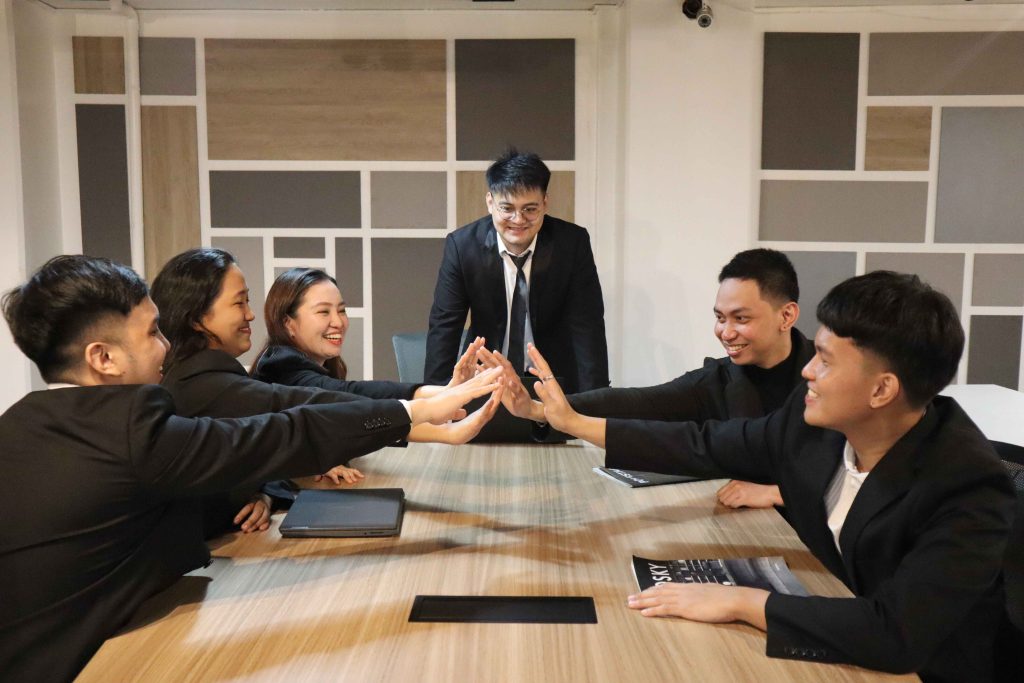 Mustard Seed colleagues high-fiving around a conference table.