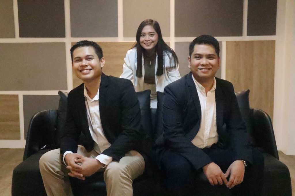Three Mustard Seed colleagues seated together on a couch.